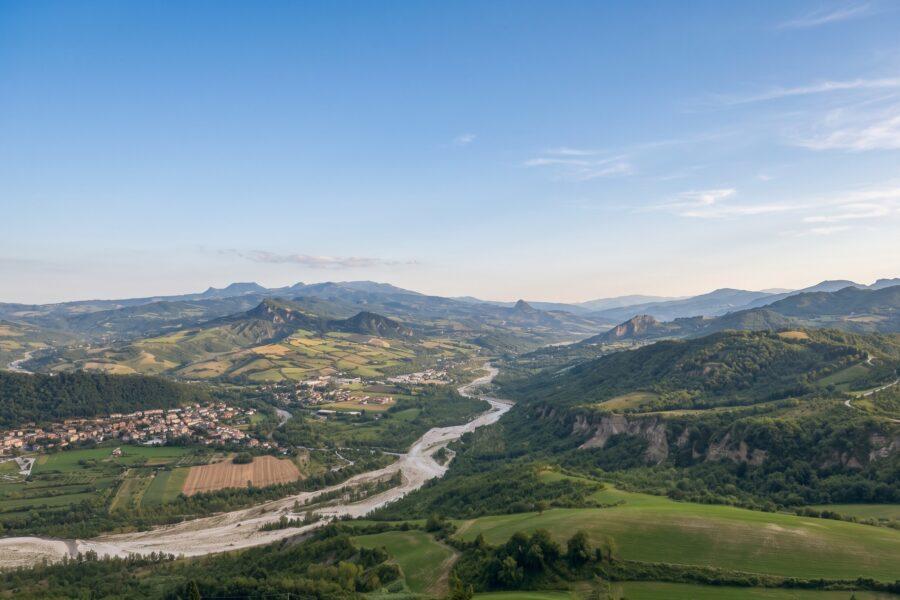 Scenic view of the rolling green hills and vineyards in Rimini, Emilia-Romagna, a prime location for buying property in Italy.