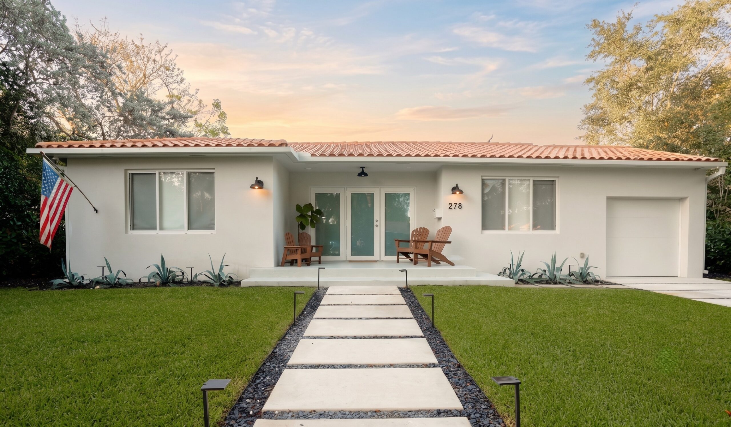 Miami Shores Residence front exterior at dusk — white stucco mid-century home with terracotta barrel-tile roof, renovated by Duoma Atelier