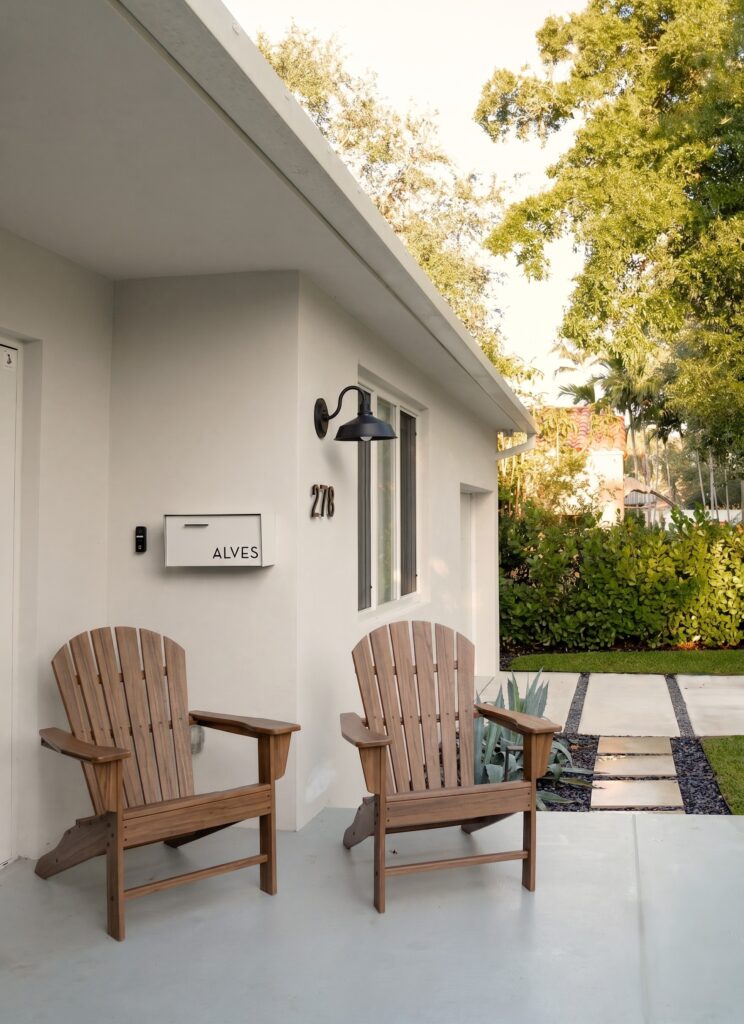 1_Frontyard_Shot_4_F Miami Shores Residence entry patio with wood Adirondack chairs — Duoma Atelier